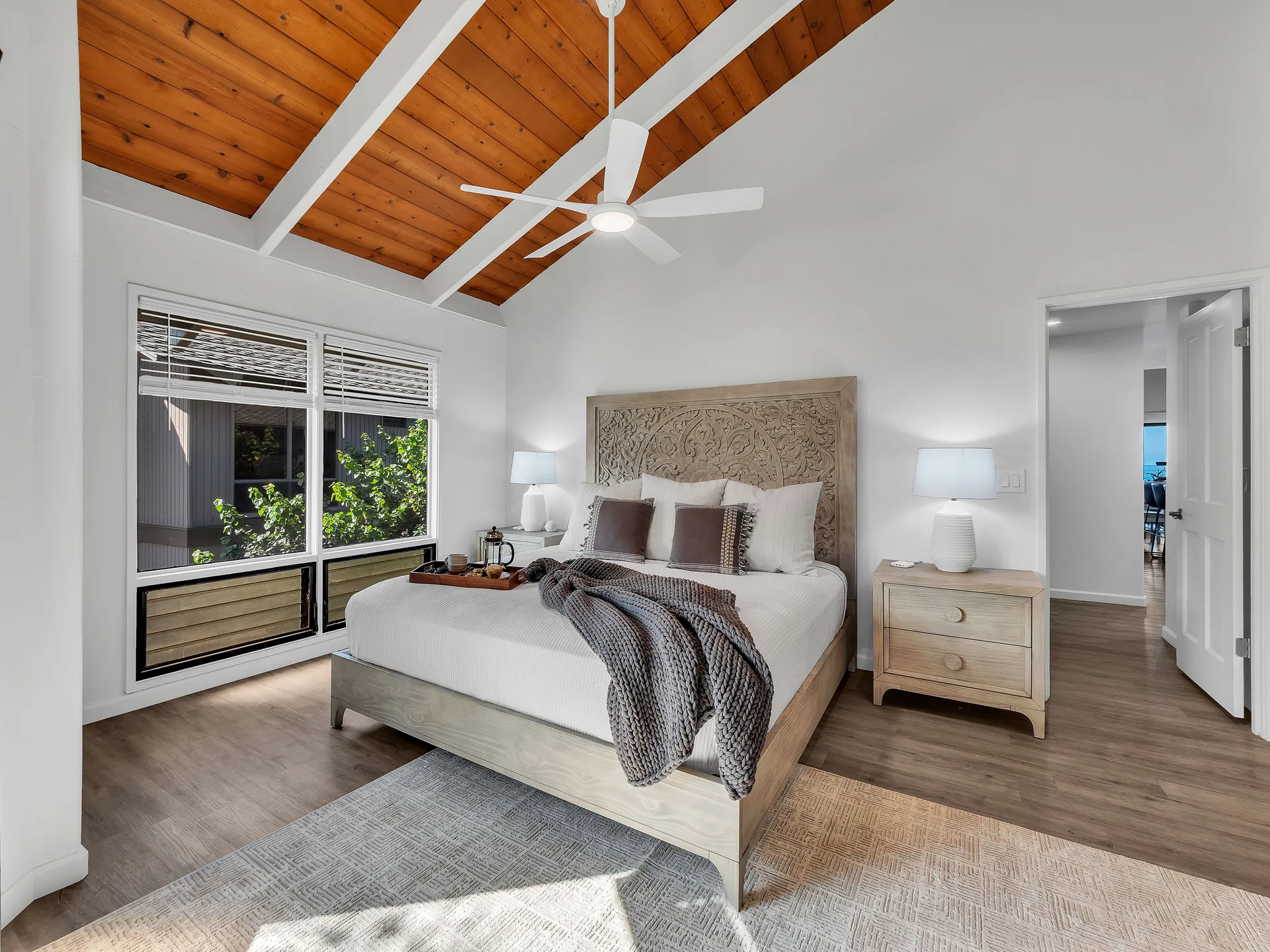 Master bedroom with vaulted wood ceiling and king bed