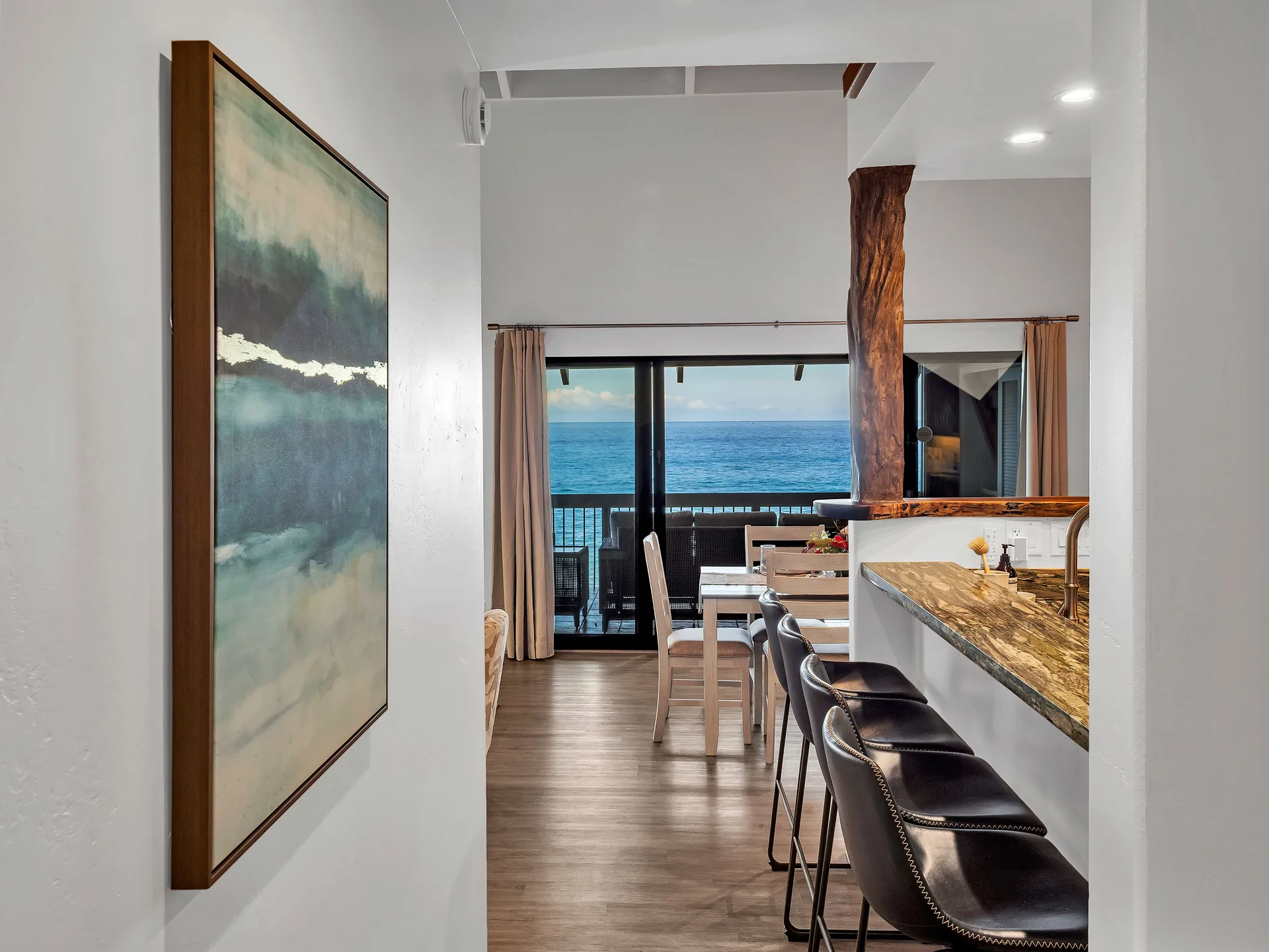 Hallway with ocean painting and kitchen bar
